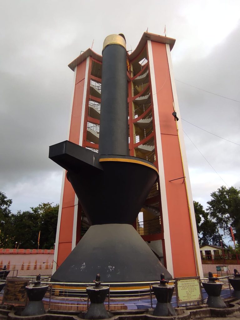 Alt Text: A majestic view of the 108-foot Shiva Linga, surrounded by temples and religious structures at Shivpuri Dham.