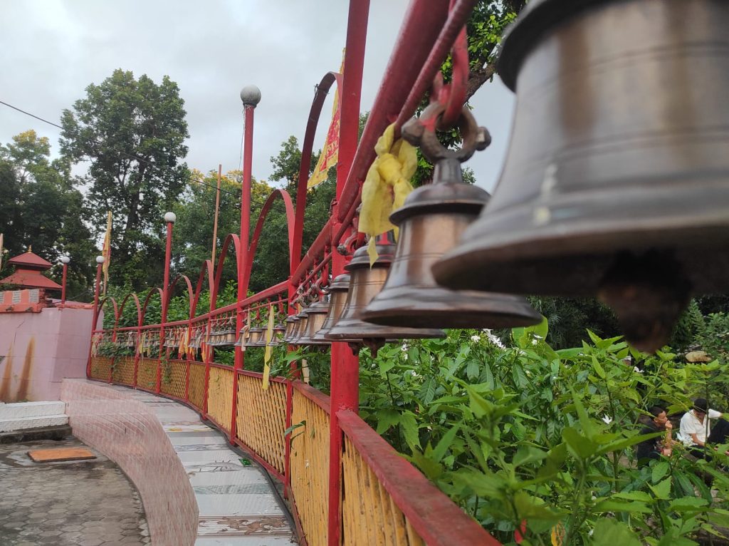 Alt Text: The sacred bull statue in front of the Shiva Linga, with nearby shrines and temples in view.